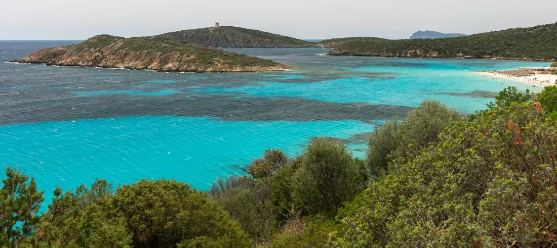 Mare turchese e isolotto con la torre nella costa di Chia e Tuerredda