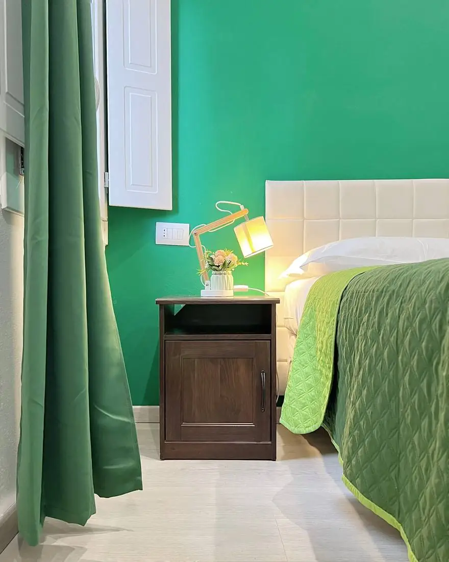 Comodino con lampada accesa e fiori