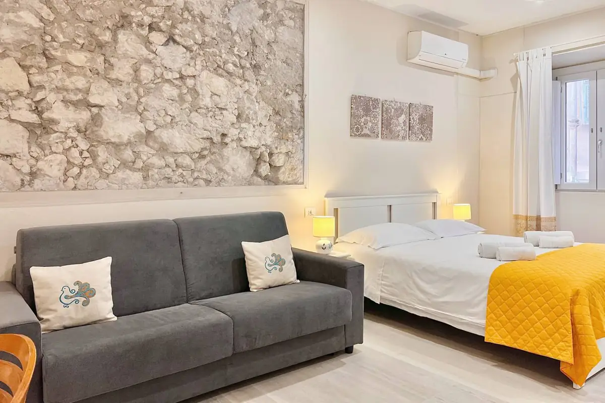 Divano letto e muro in pietra a vista